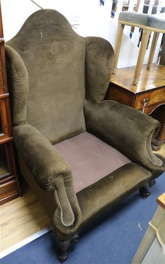 A pair of George II wing back armchairs, upholstered in brown dralon (lacking cushions)